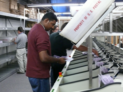 Elections staff begin processing ballots on the Pitney Bowes Relia-Vote system